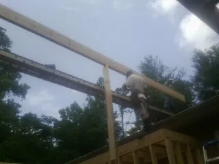 Carpenter setting a ridge beam over a new addition frame — Ice Dam Removal by Roofing Brothers in Bensalem