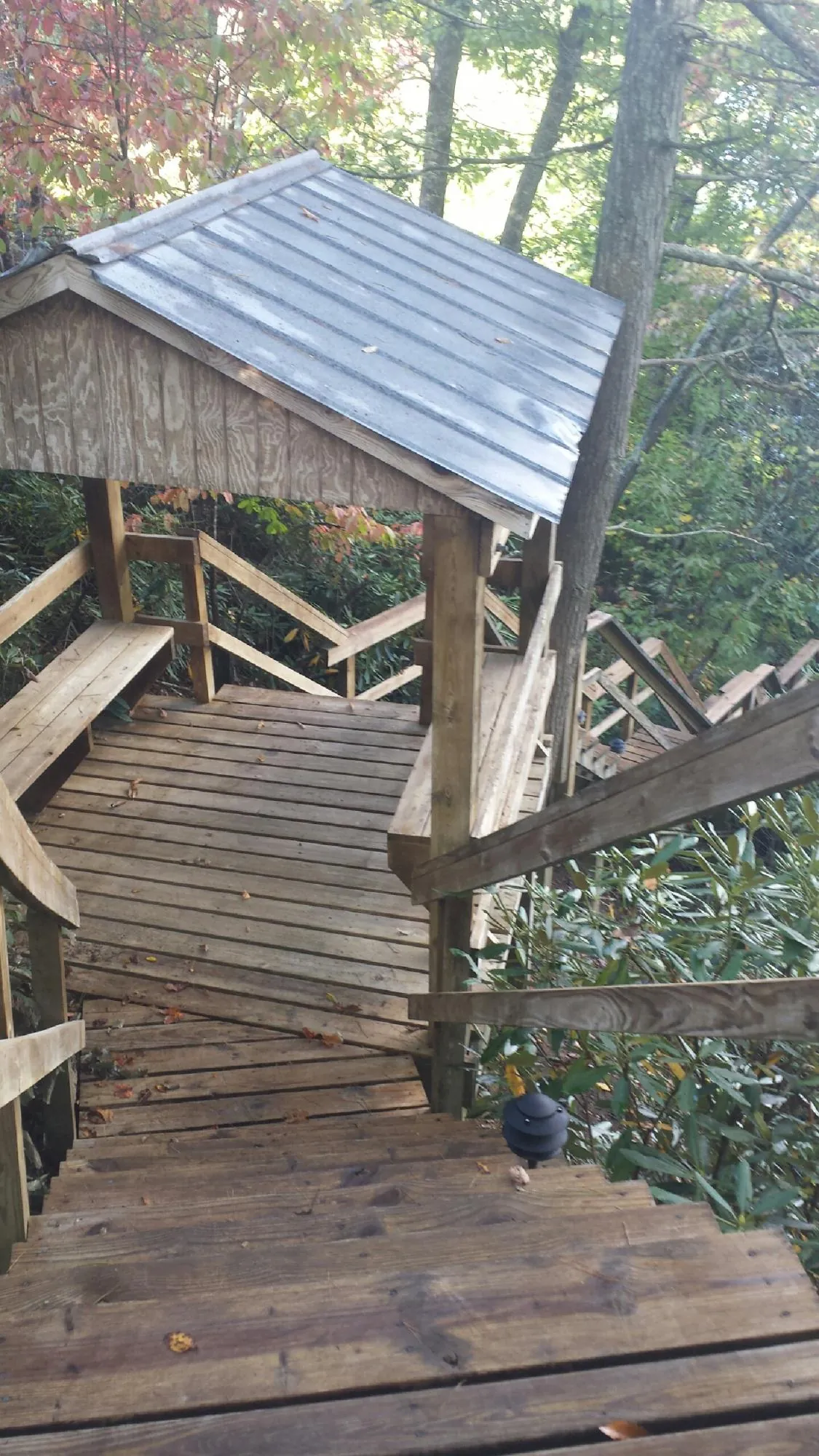 Metal roofed shelter over wooden steps on a wooded walkway — Skylight Repair & Installation work by our crew in Bensalem